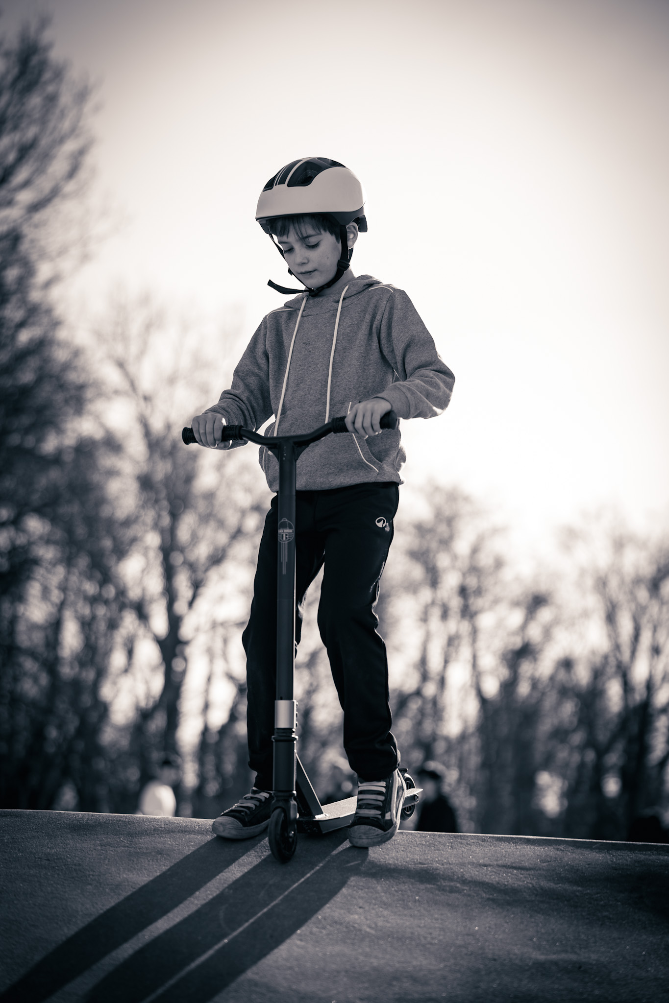Boy on scooter, sunset at skatepark