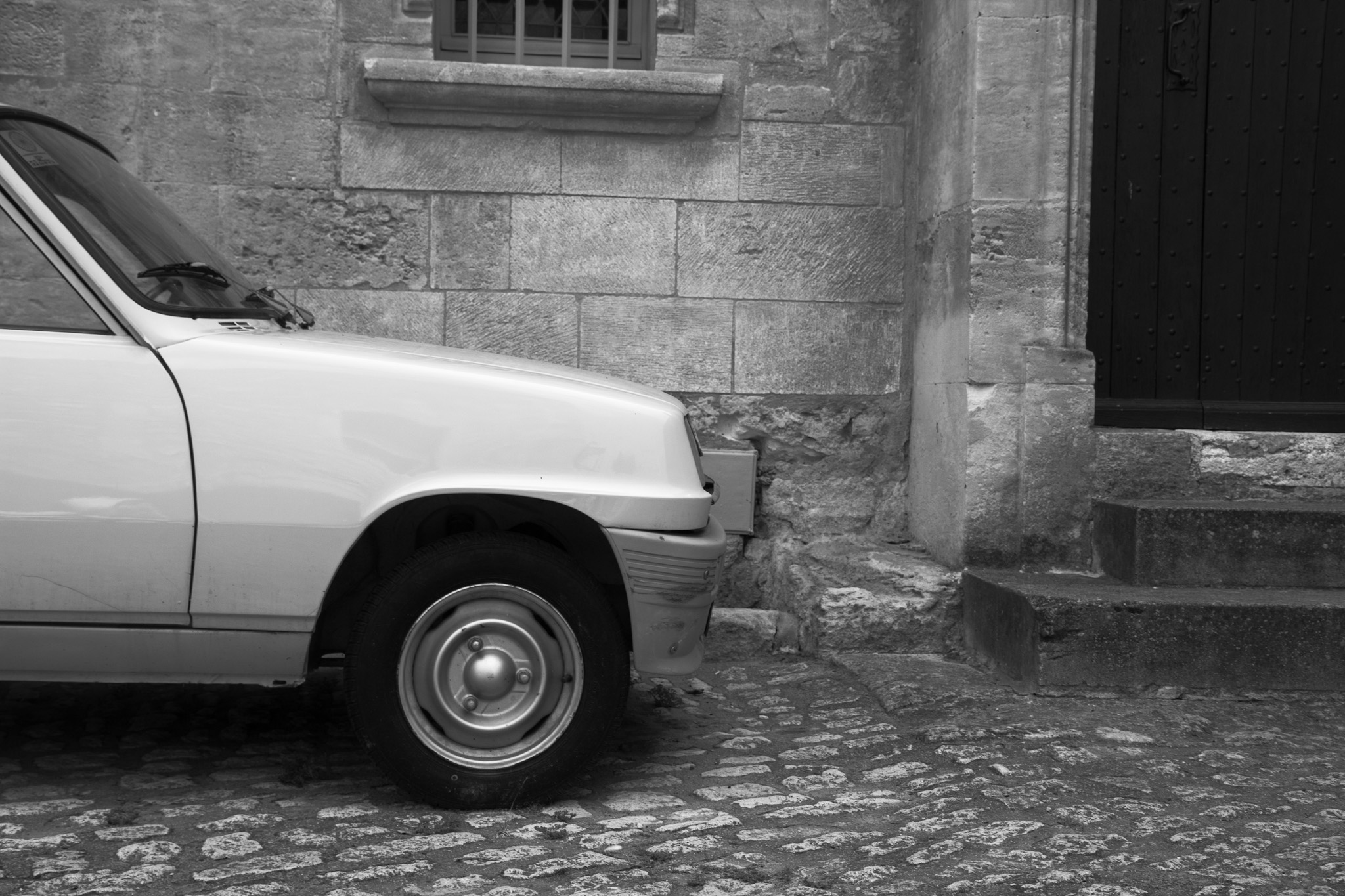 Old car in old town center, black and white