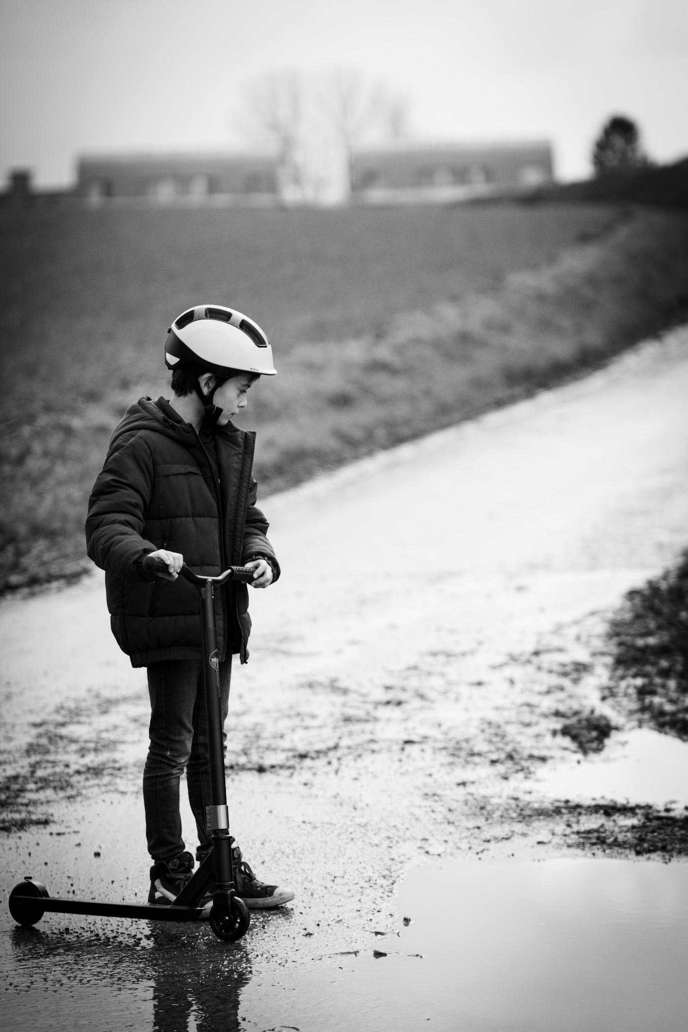 Boy on the street near water puddle