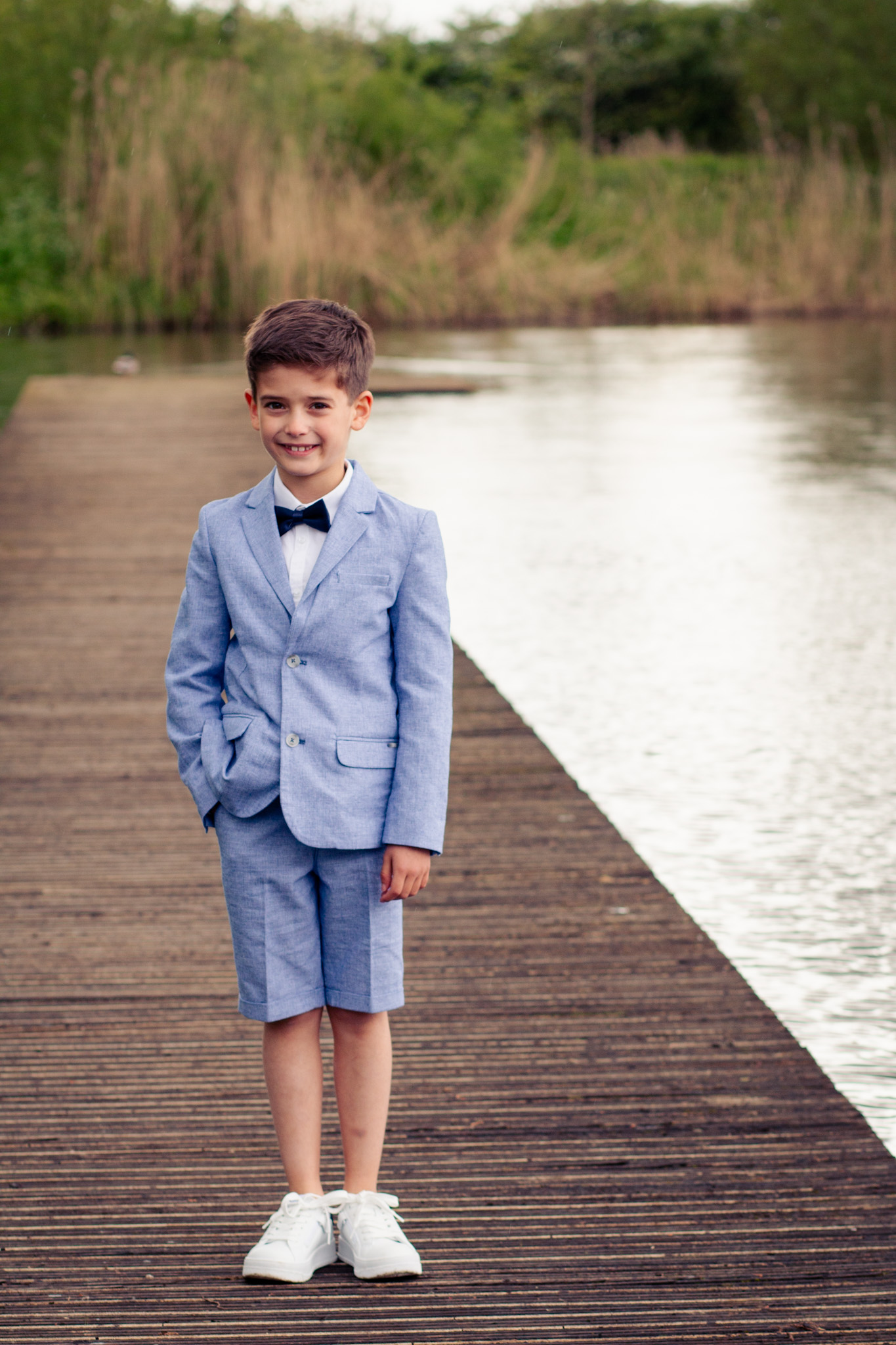 Communie foto jongen, poserend bij water op wandelpad